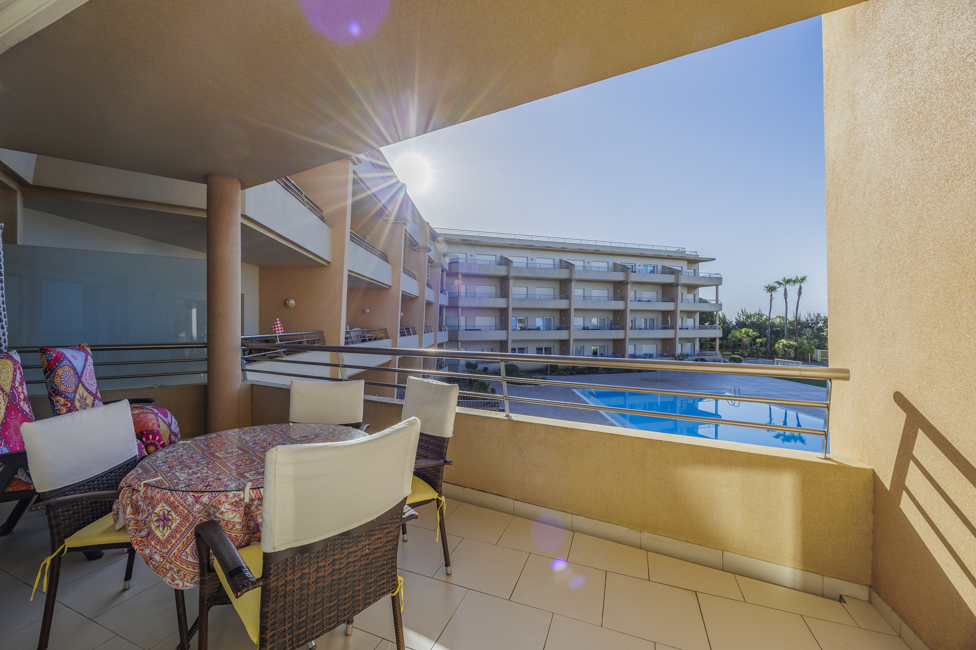 Balcony with dining table, chairs, and pool view