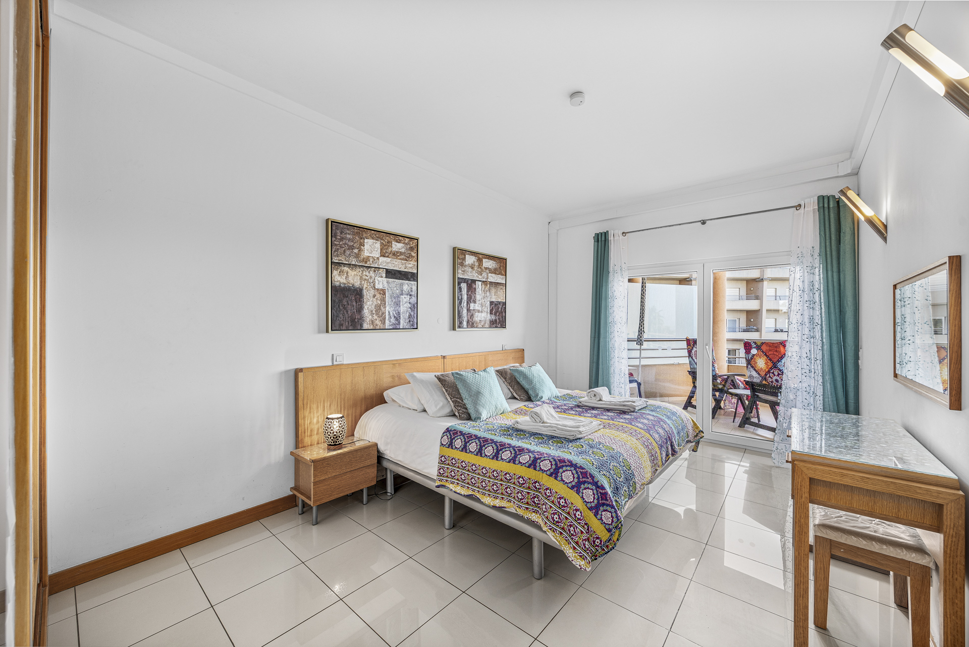Bedroom with double bed, colourful bedspread, and twin bedside tables