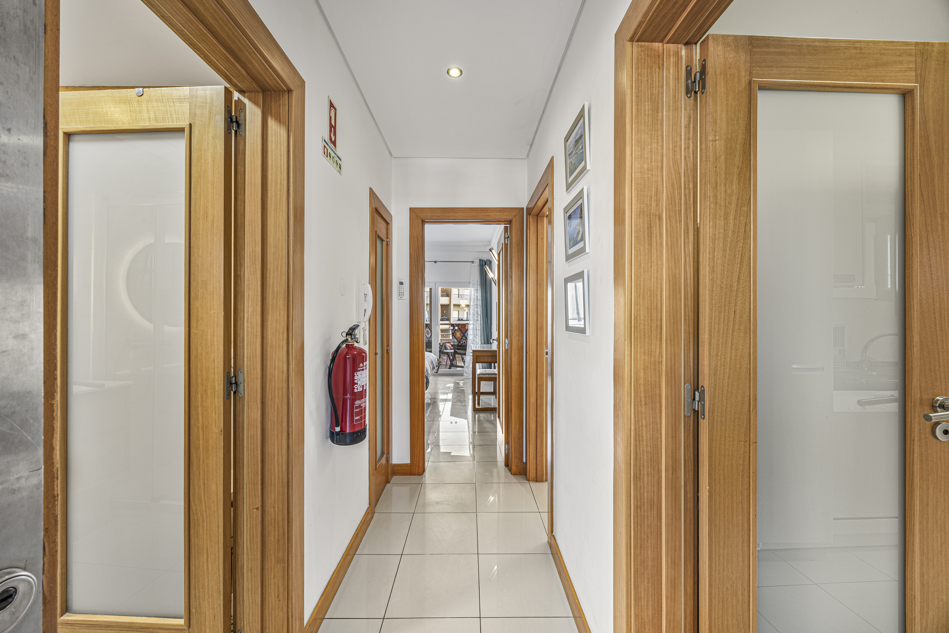 Hallway with tiled flooring and doors leading to the bedroom and bathroom