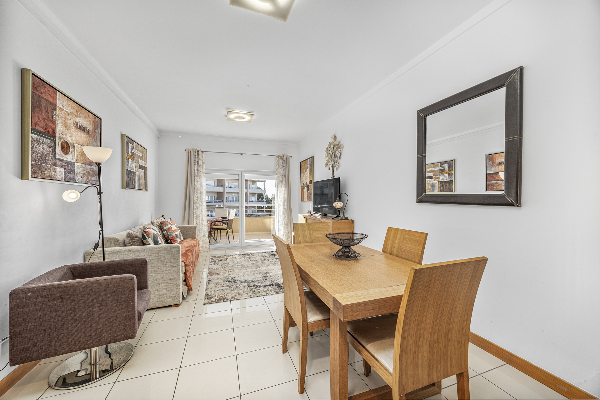 Living room with armchair, sofa, and dining table beyond