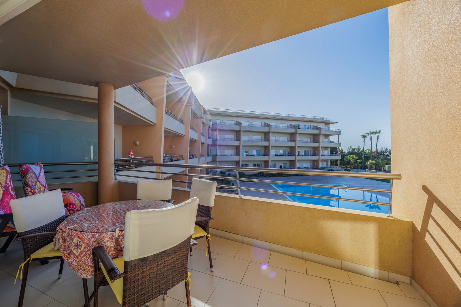 Balcony with dining table, chairs, and pool view