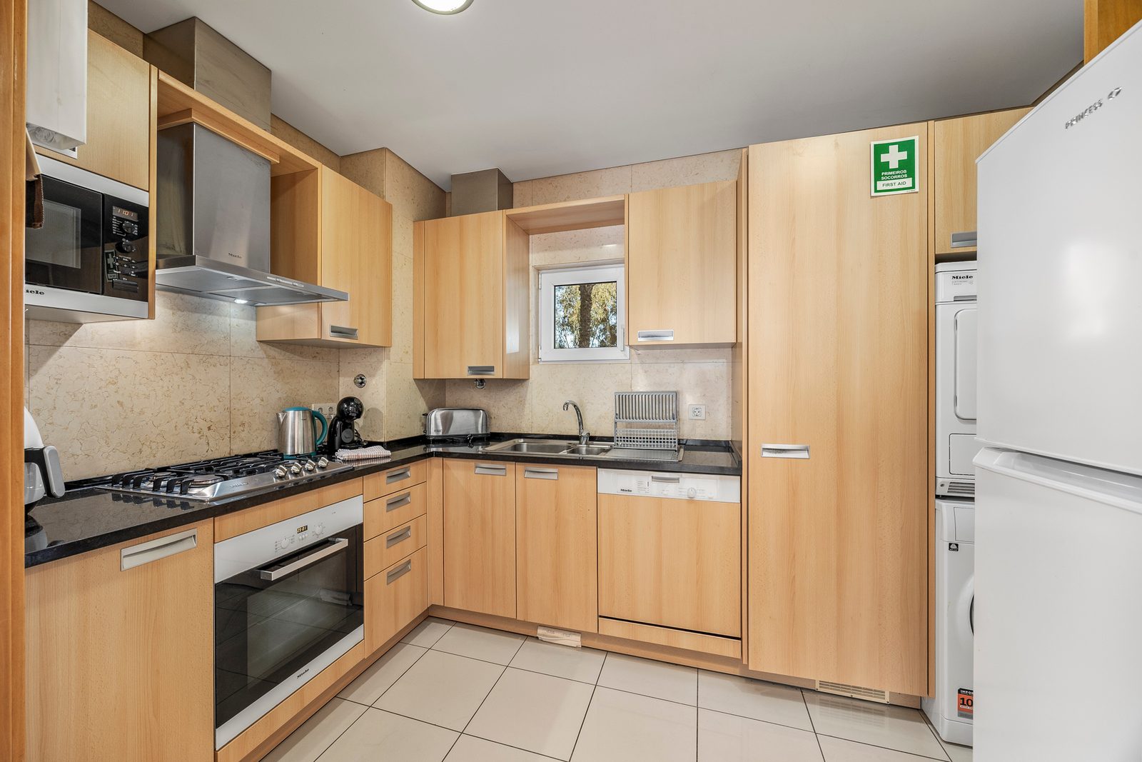 Kitchen with gas hob, extractor hood, and fridge-freezer