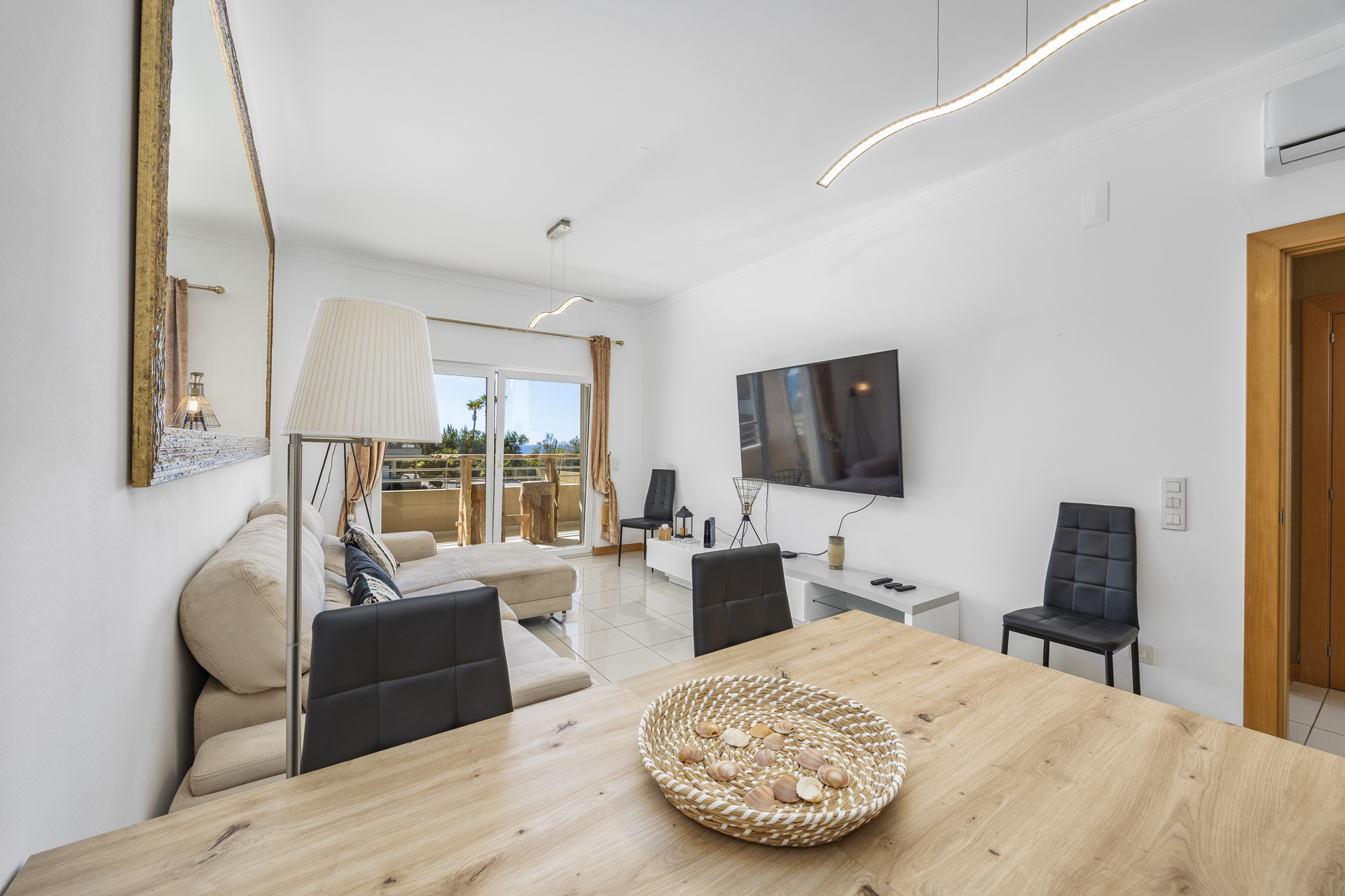 Dining area with wooden table for four and a view through to the living room