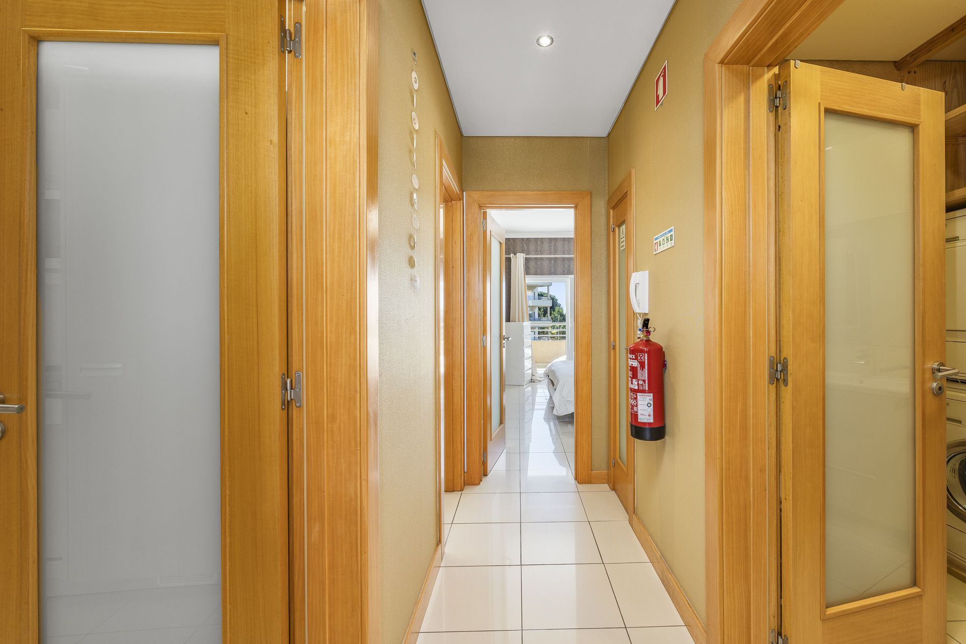 Hallway with tiled flooring and doors leading to the bedroom and bathroom