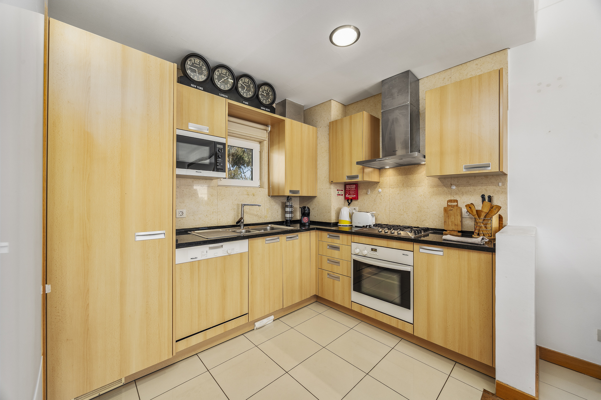 Kitchen with gas hob, extractor hood, and fitted wooden cabinetry