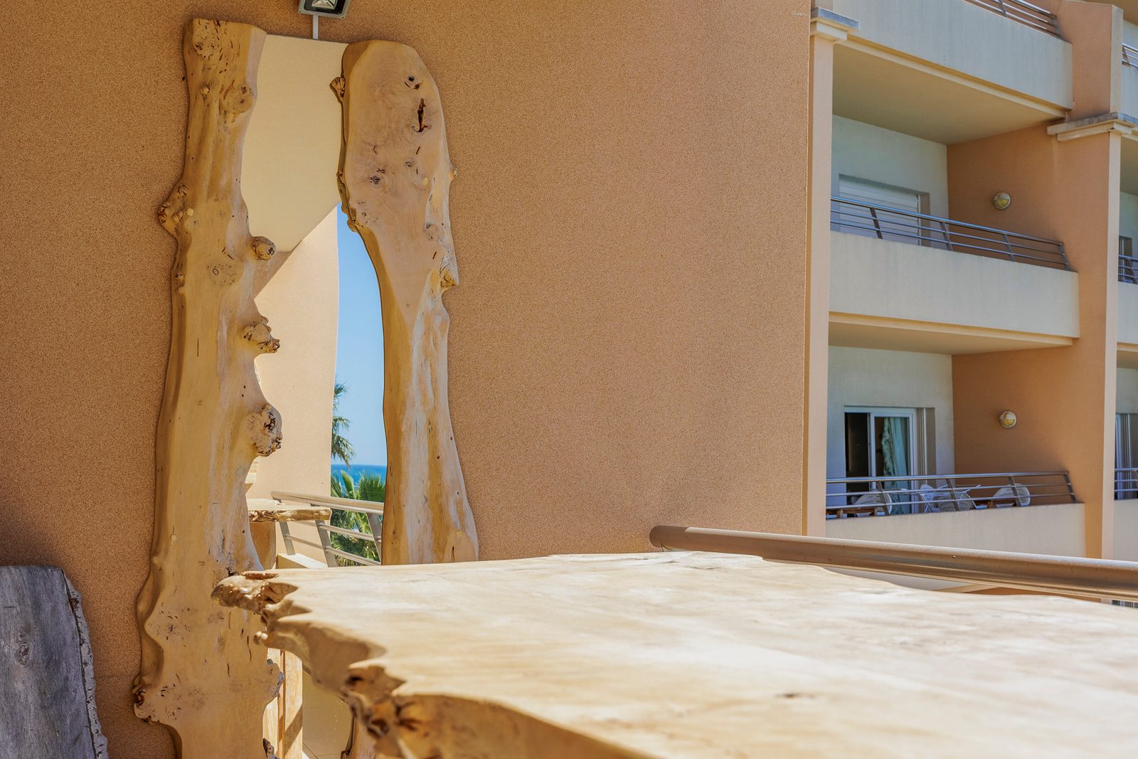 Close-up of the balcony's live-edge wooden table against the building view
