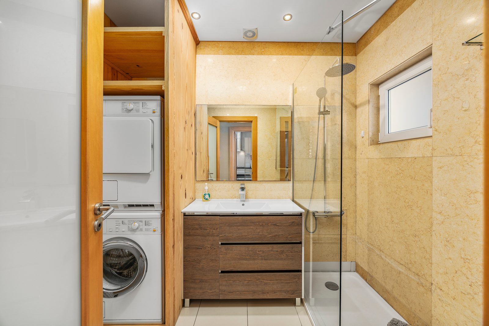 Bathroom with walk-in shower, stacked washer-dryer, and vanity sink