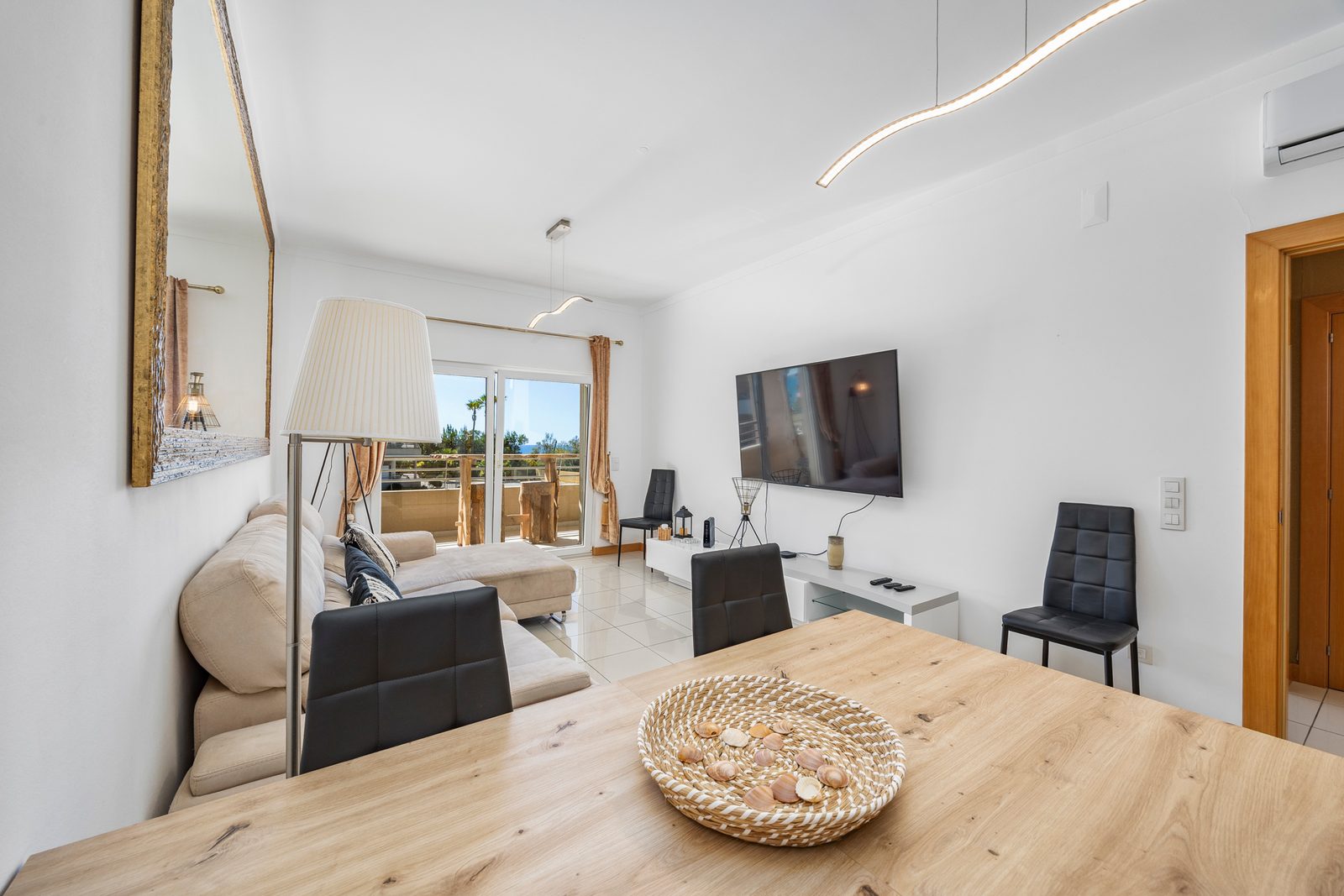 Dining area with wooden table for four and a view through to the living room