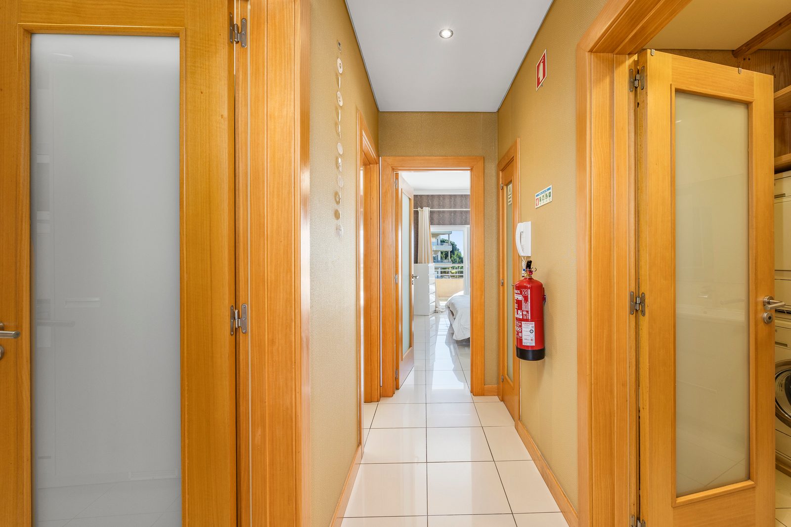 Hallway with tiled flooring and doors leading to the bedroom and bathroom