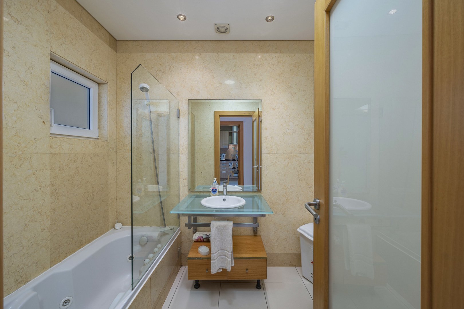Bathroom with bathtub, glass shower screen, and vanity sink