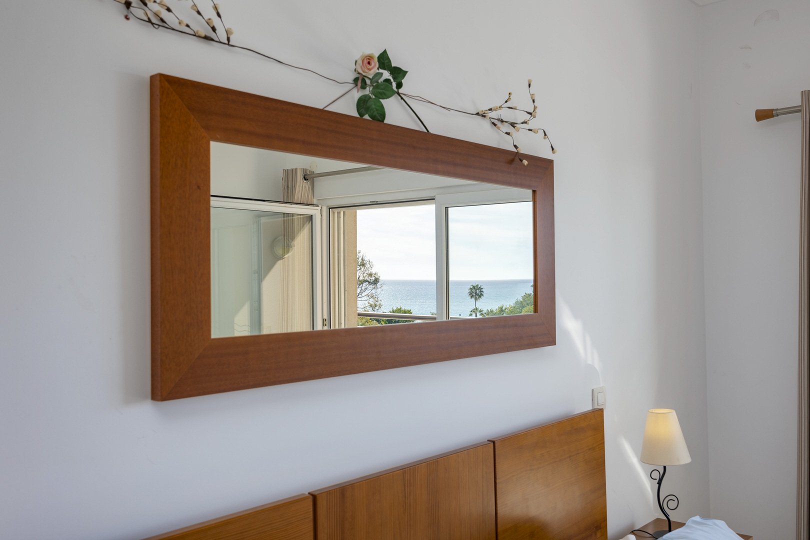 Bedroom mirror reflecting the sea view through the balcony window