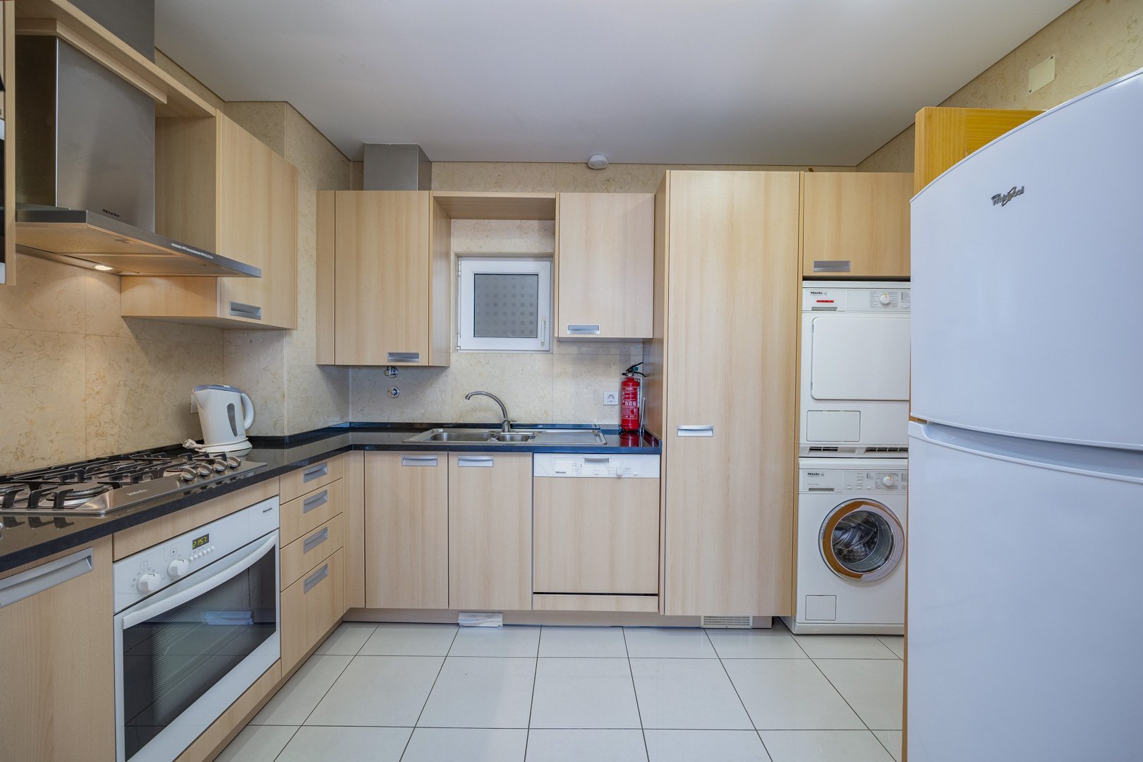 Kitchen with fridge and stacked washer-dryer