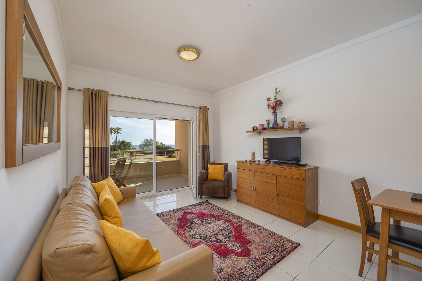 Living room with sofa, TV, and sea-view balcony access