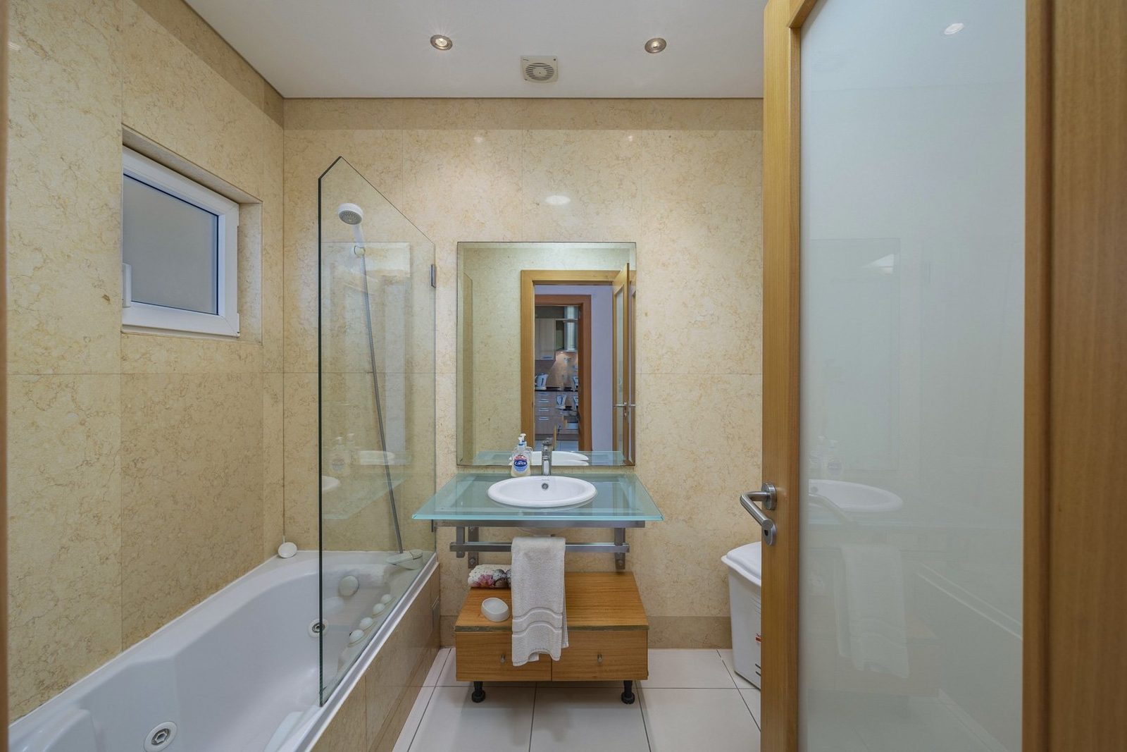 Bathroom with bathtub, glass shower screen, and vanity sink