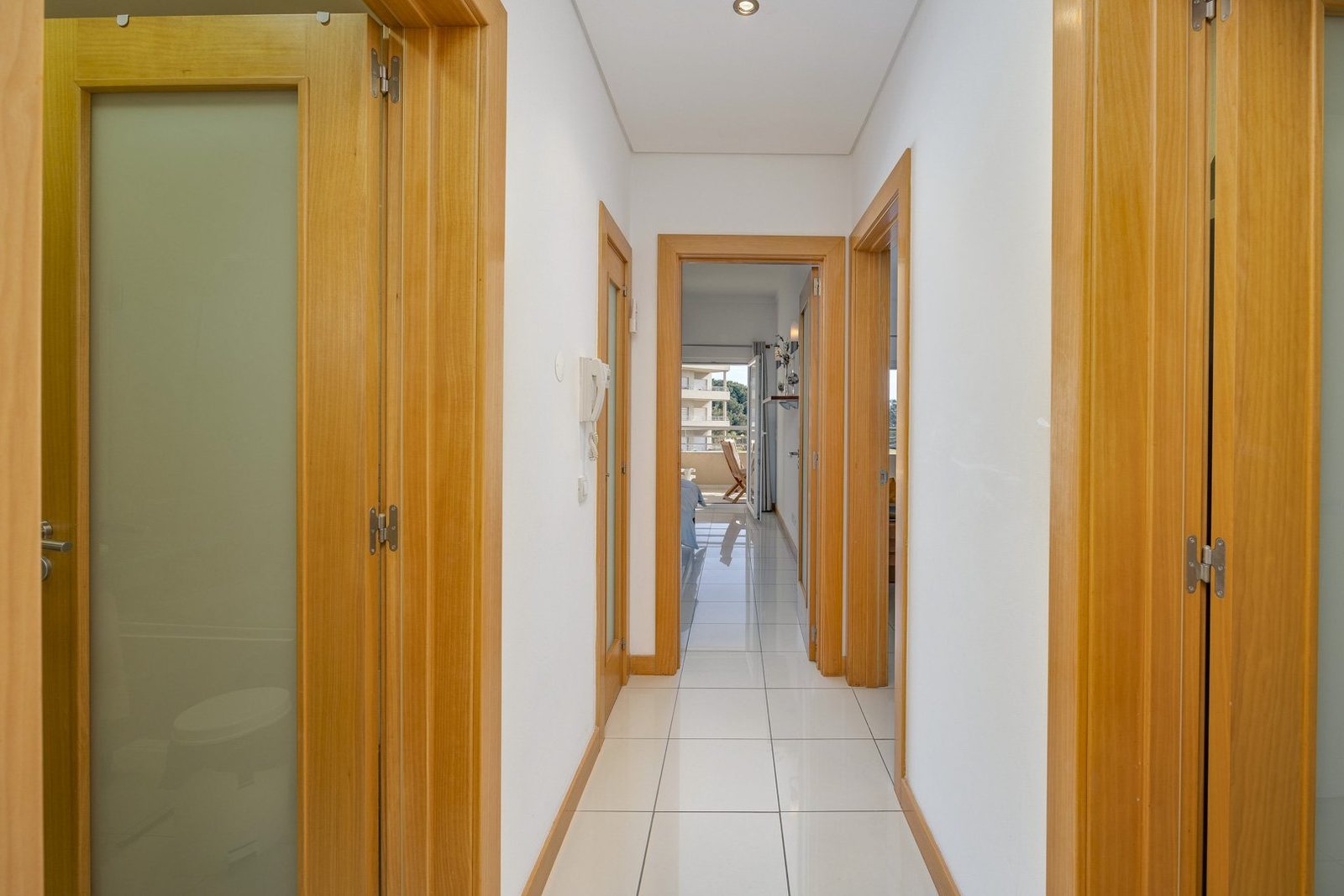 Hallway with wooden doors leading to the bedroom and living area