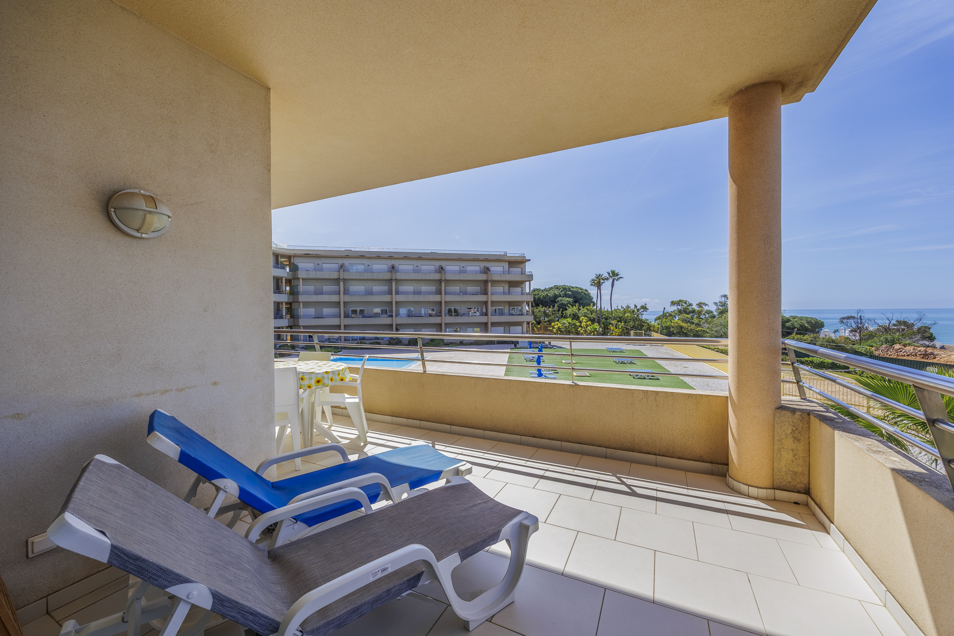 Balcony corner with lounge chairs and pool view
