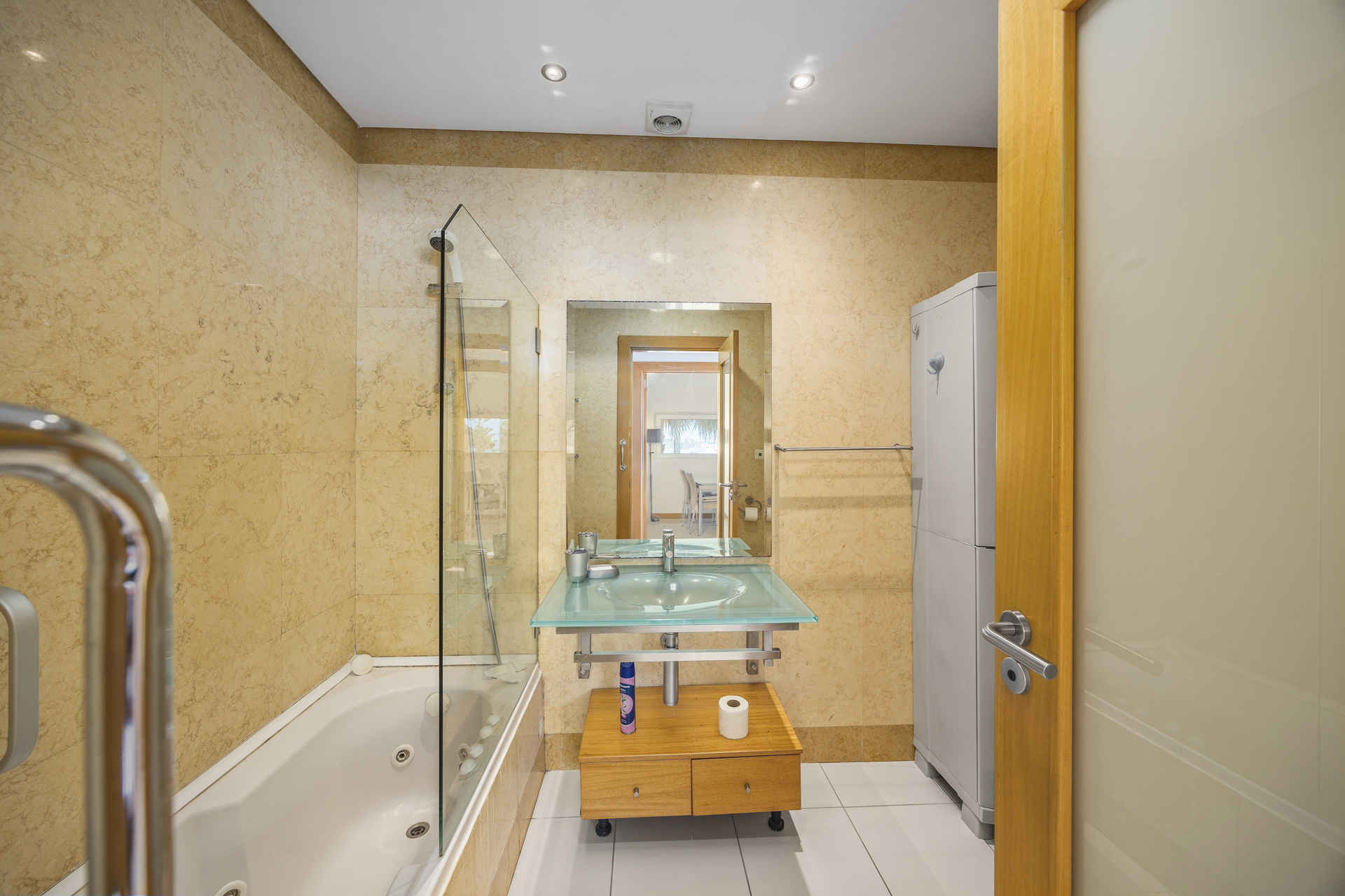 Bathroom with corner bathtub, glass shower screen, and vanity sink