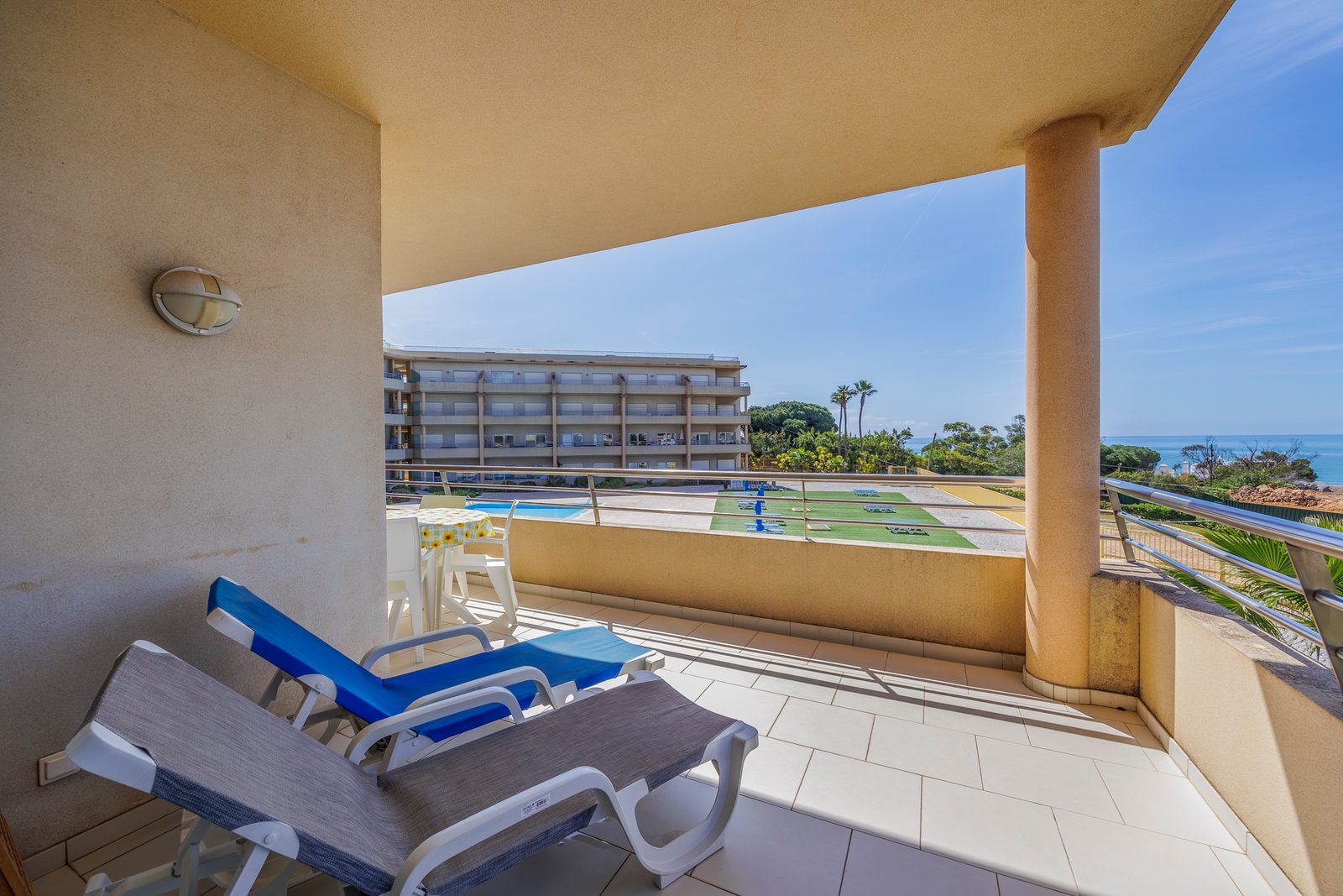 Balcony corner with lounge chairs and pool view