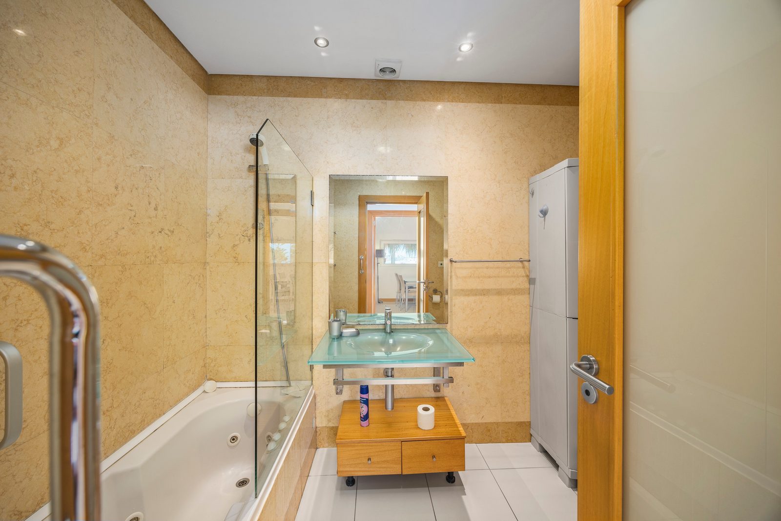 Bathroom with corner bathtub, glass shower screen, and vanity sink
