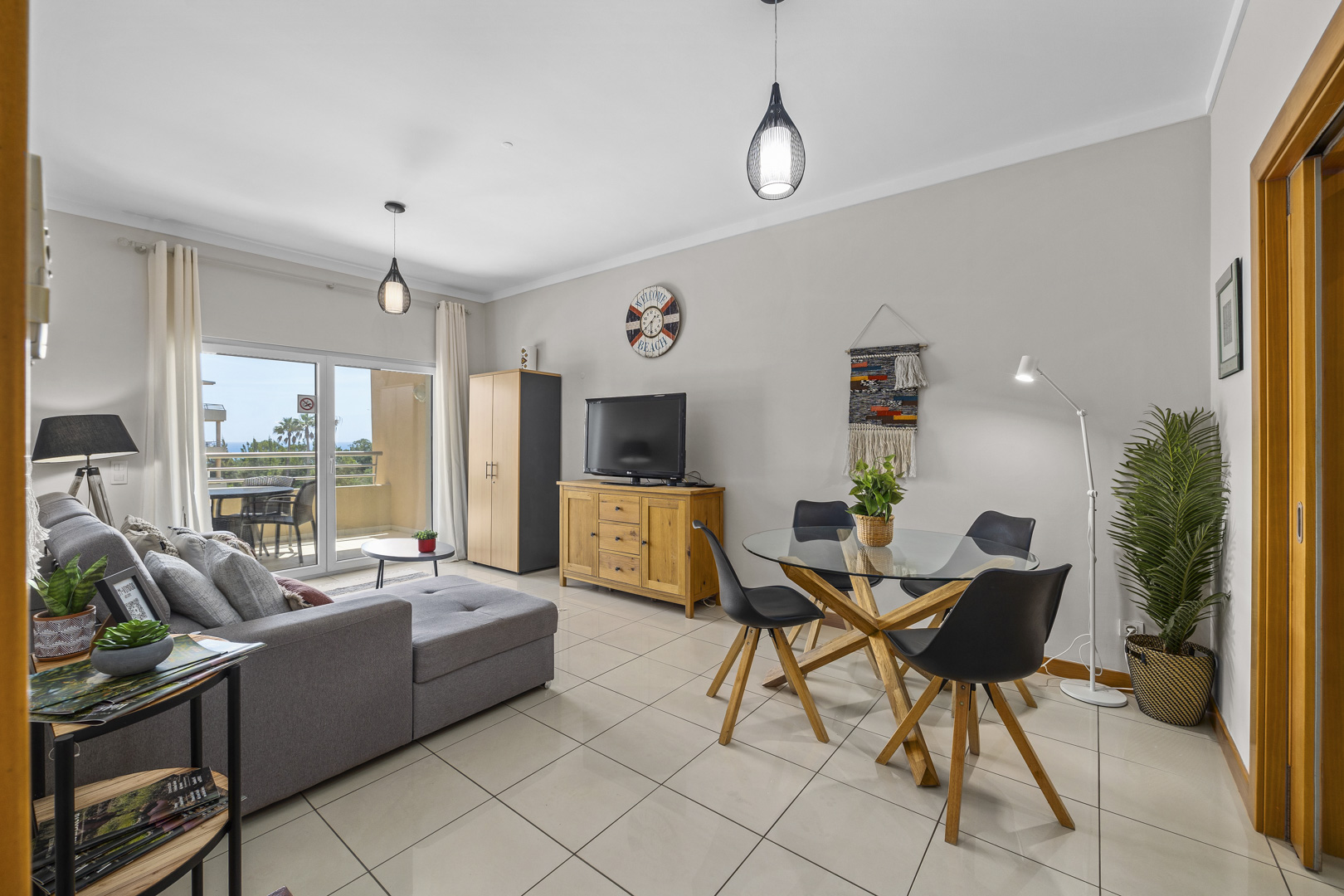 Living and dining area with sofa, dining table, and cabinet storage