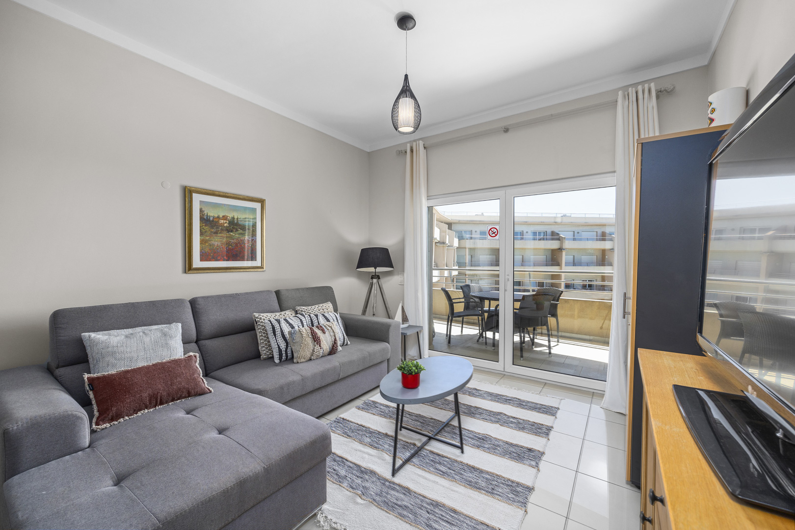 Living room with sofa and view through to the balcony dining area