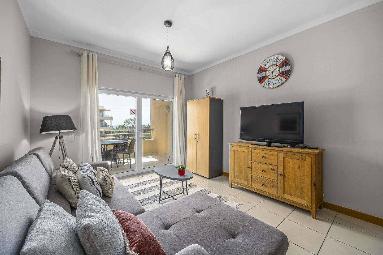 Living room with sofa, TV, and wall clock