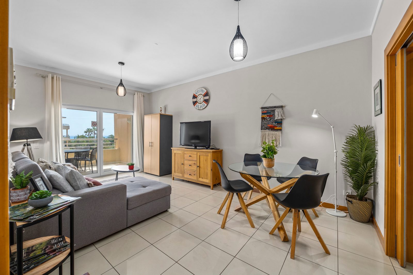 Living and dining area with sofa, dining table, and cabinet storage