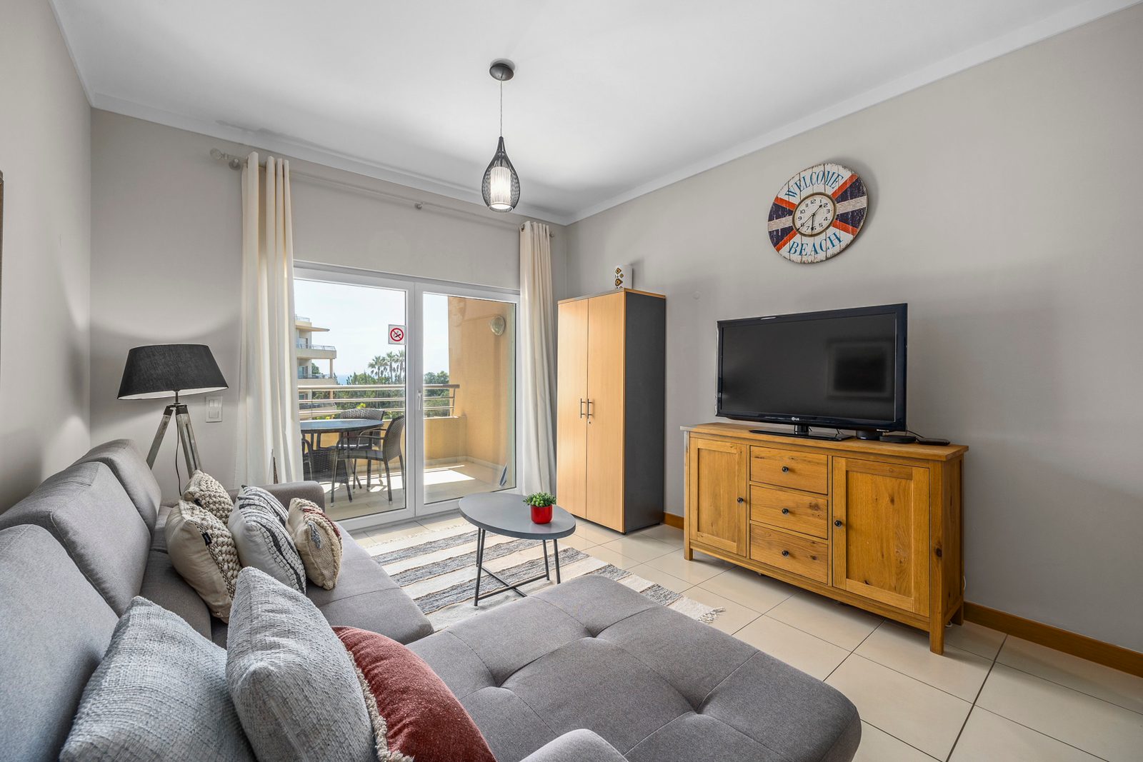 Living room with sofa, TV, and wall clock