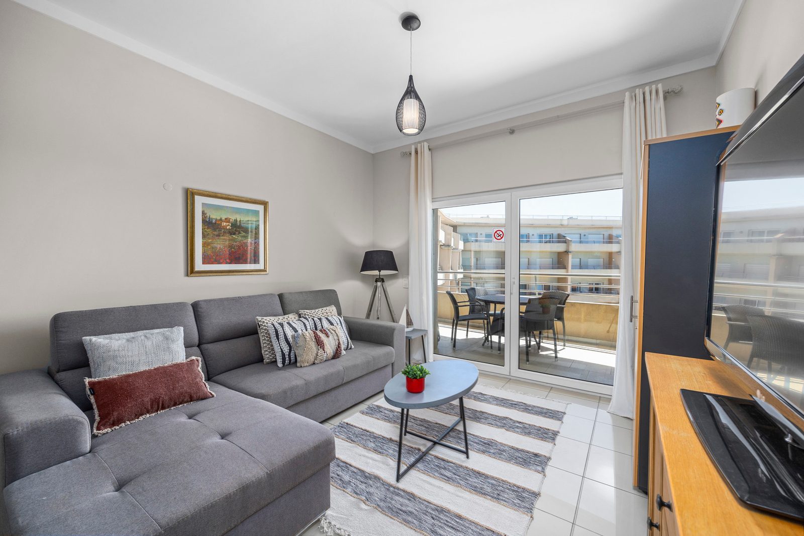 Living room with sofa and view through to the balcony dining area