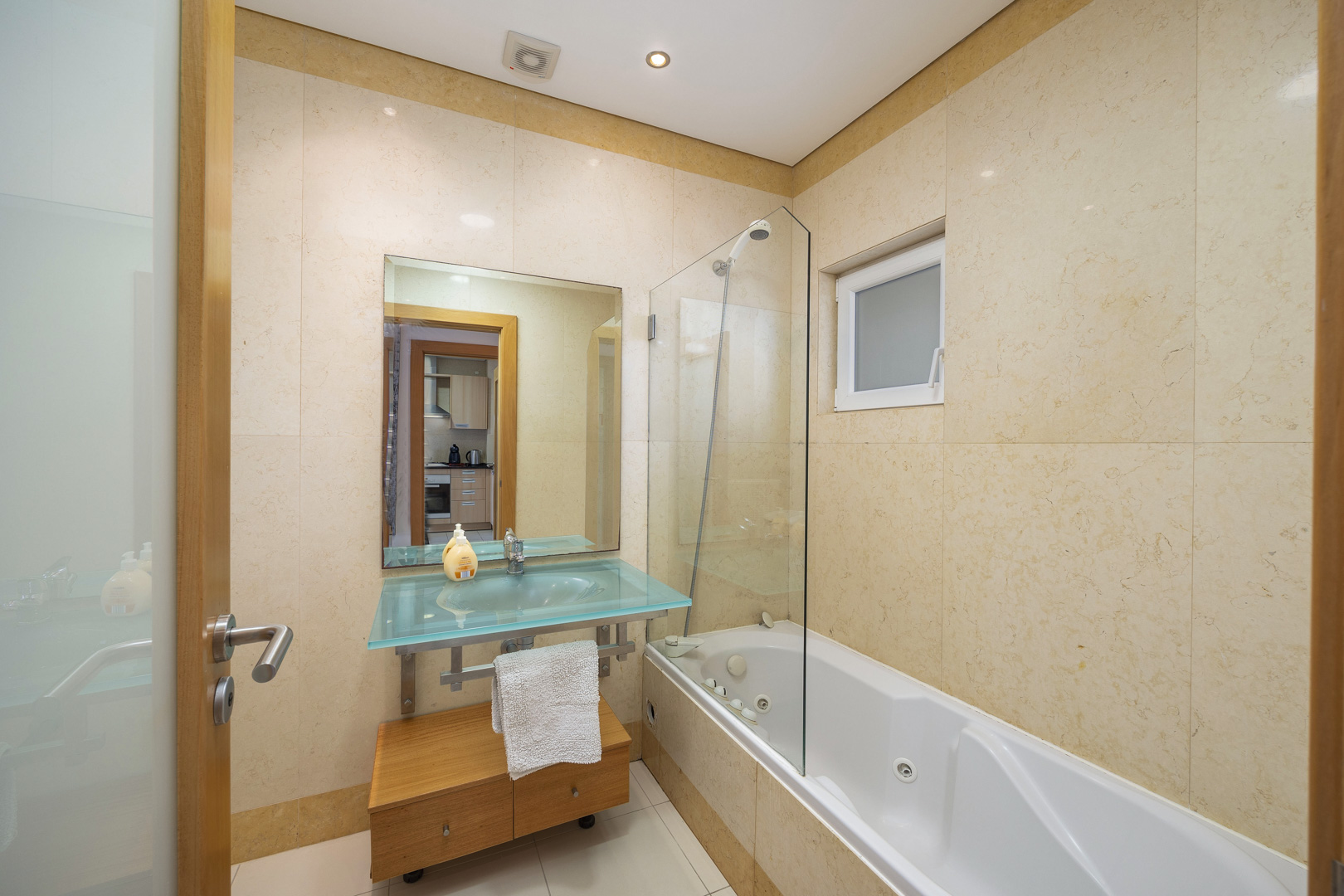 Bathroom with jacuzzi bathtub, glass shower screen, and vanity sink