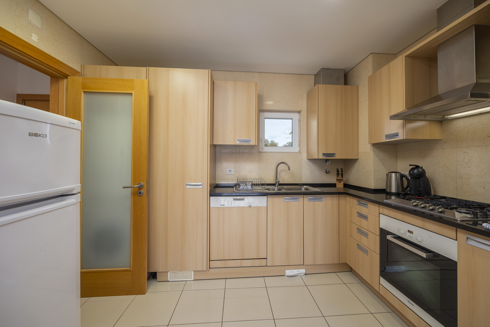 Kitchen with fridge, dishwasher, and gas hob