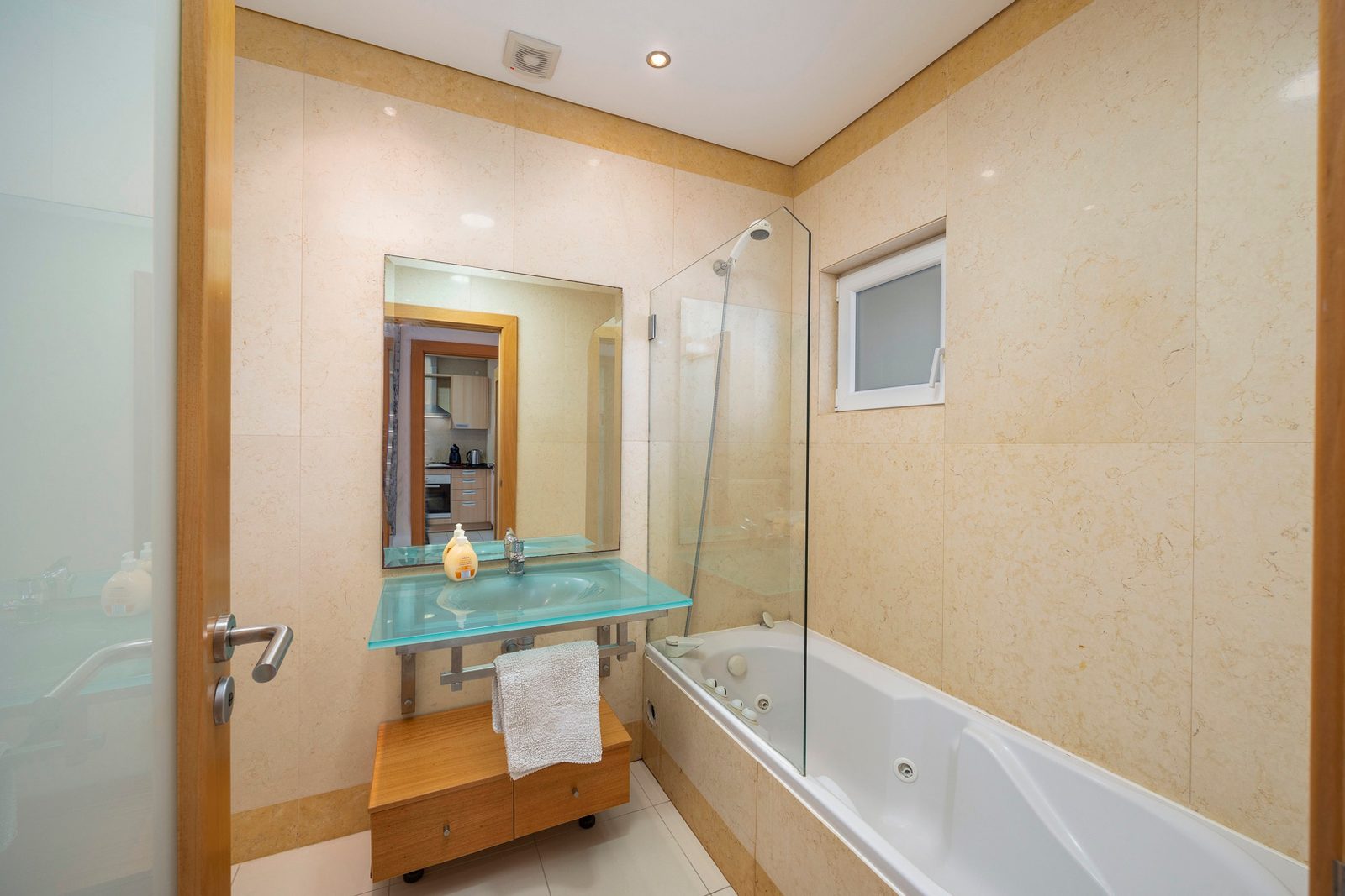 Bathroom with jacuzzi bathtub, glass shower screen, and vanity sink