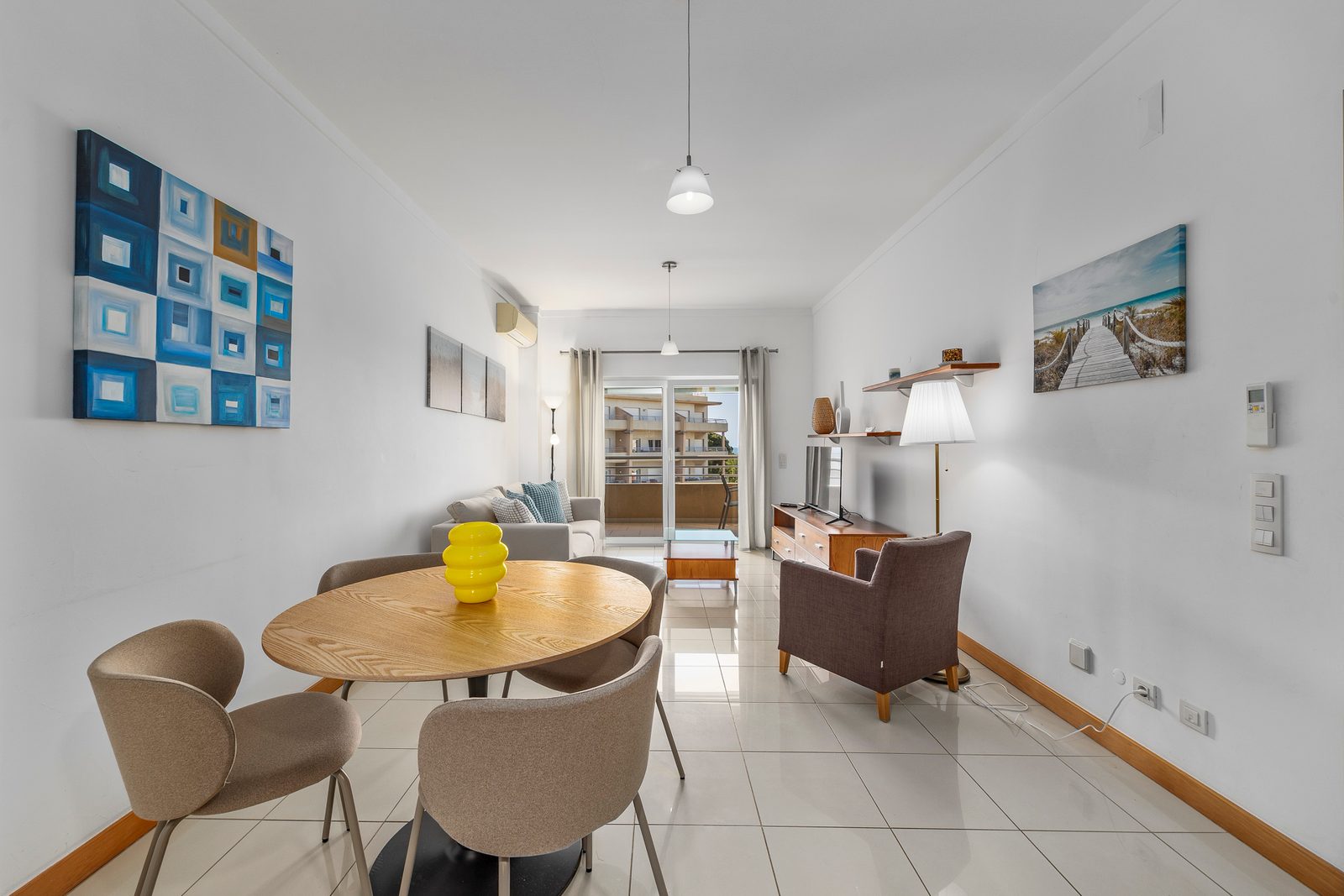 Living and dining area with round table and balcony access