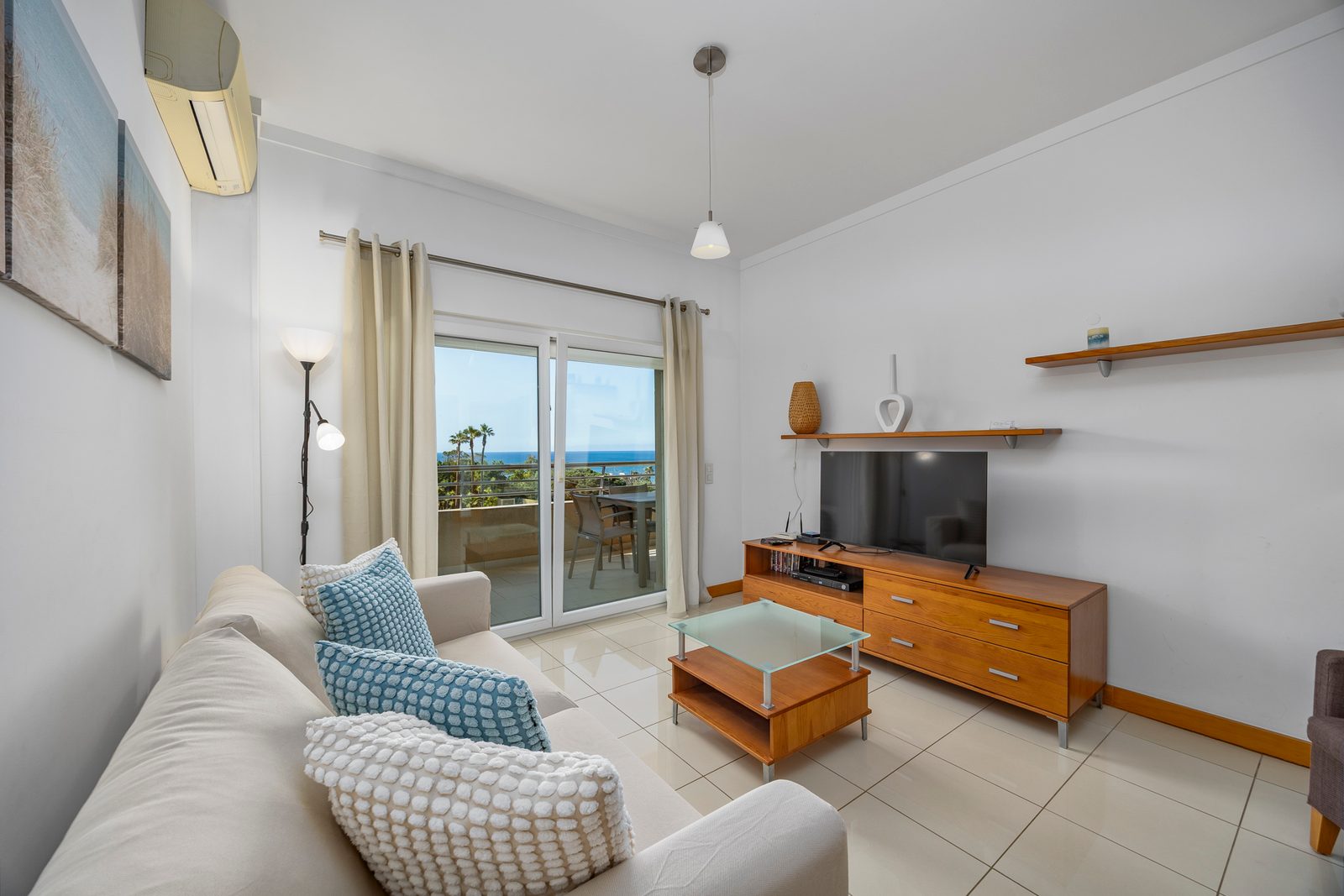 Living room with sofa and sea-view balcony access