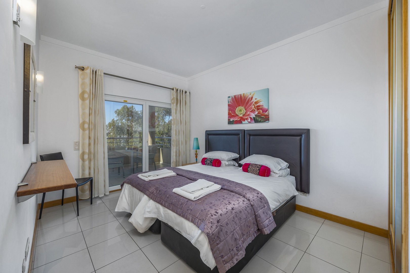 Bedroom with leather headboard and balcony access