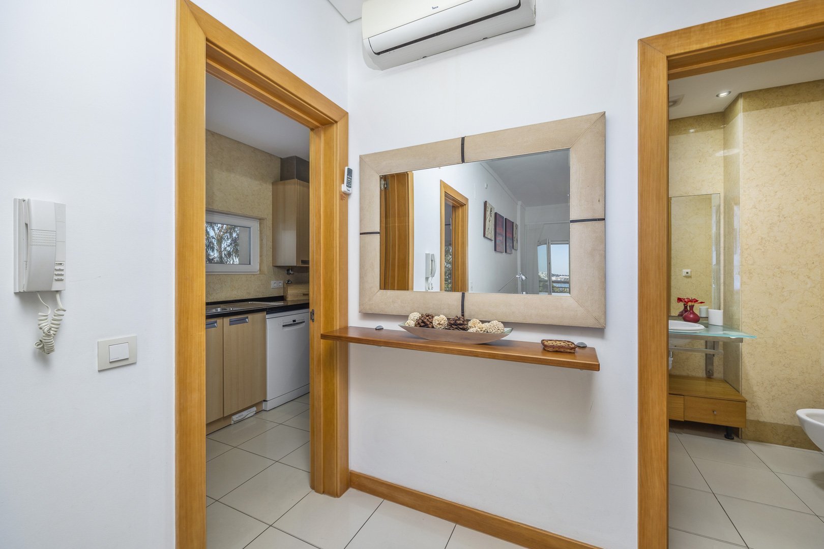 Hallway with console table, mirror, and views through to the kitchen and bathroom