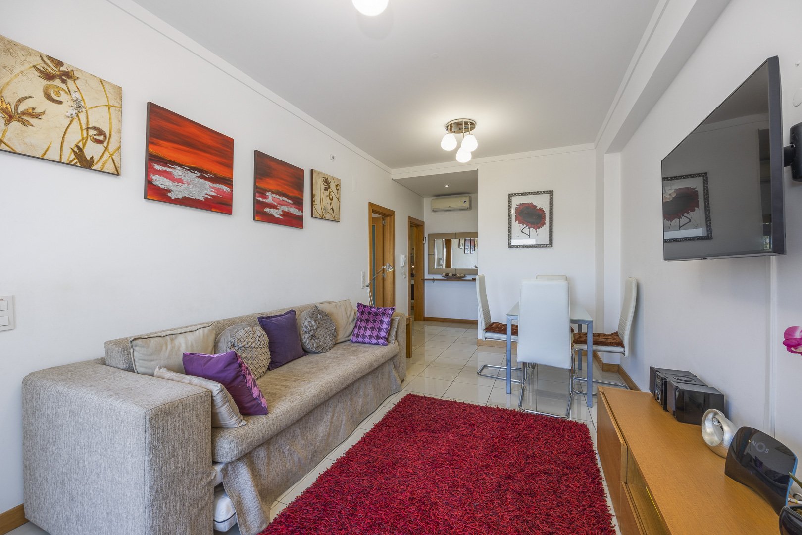 Living area with sofa, framed artwork, and dining table