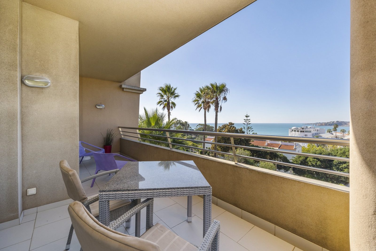 Balcony with dining table, chairs, and sea view