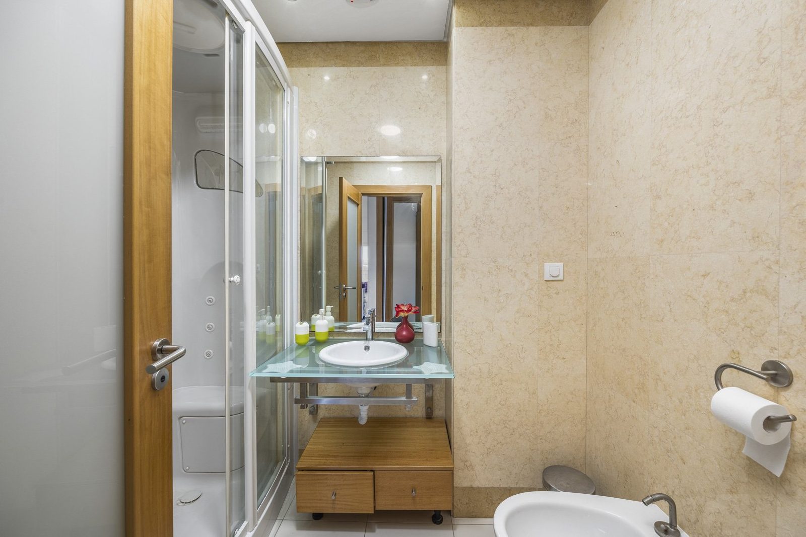 Bathroom with corner shower, bidet, and wall-mounted sink