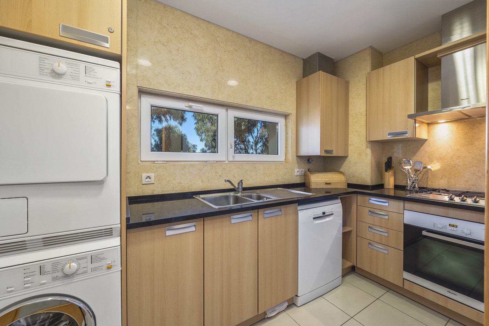 Kitchen with dishwasher and a stacked washer-dryer alcove