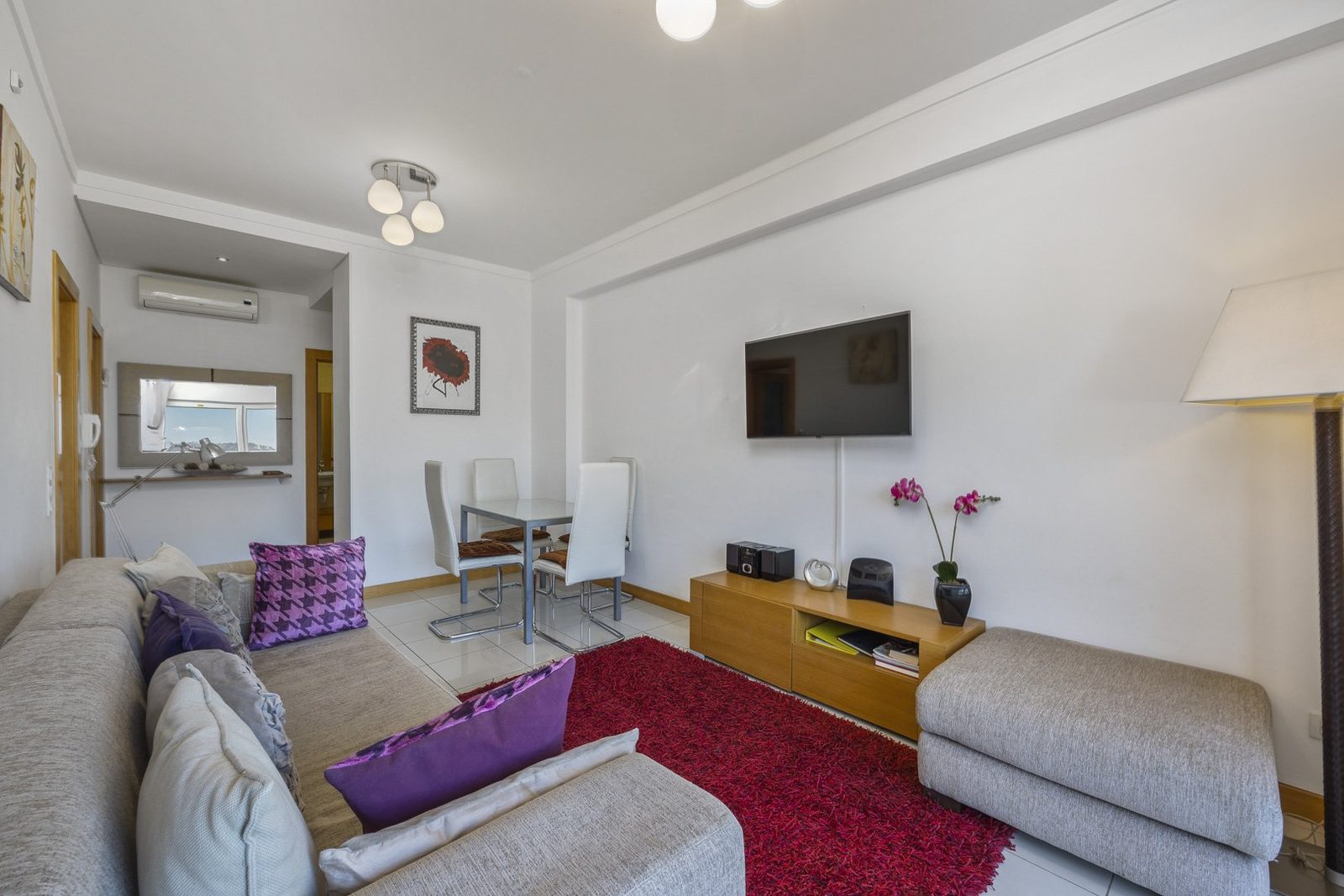 Living and dining area with dining table, sofa, and sea-view balcony access