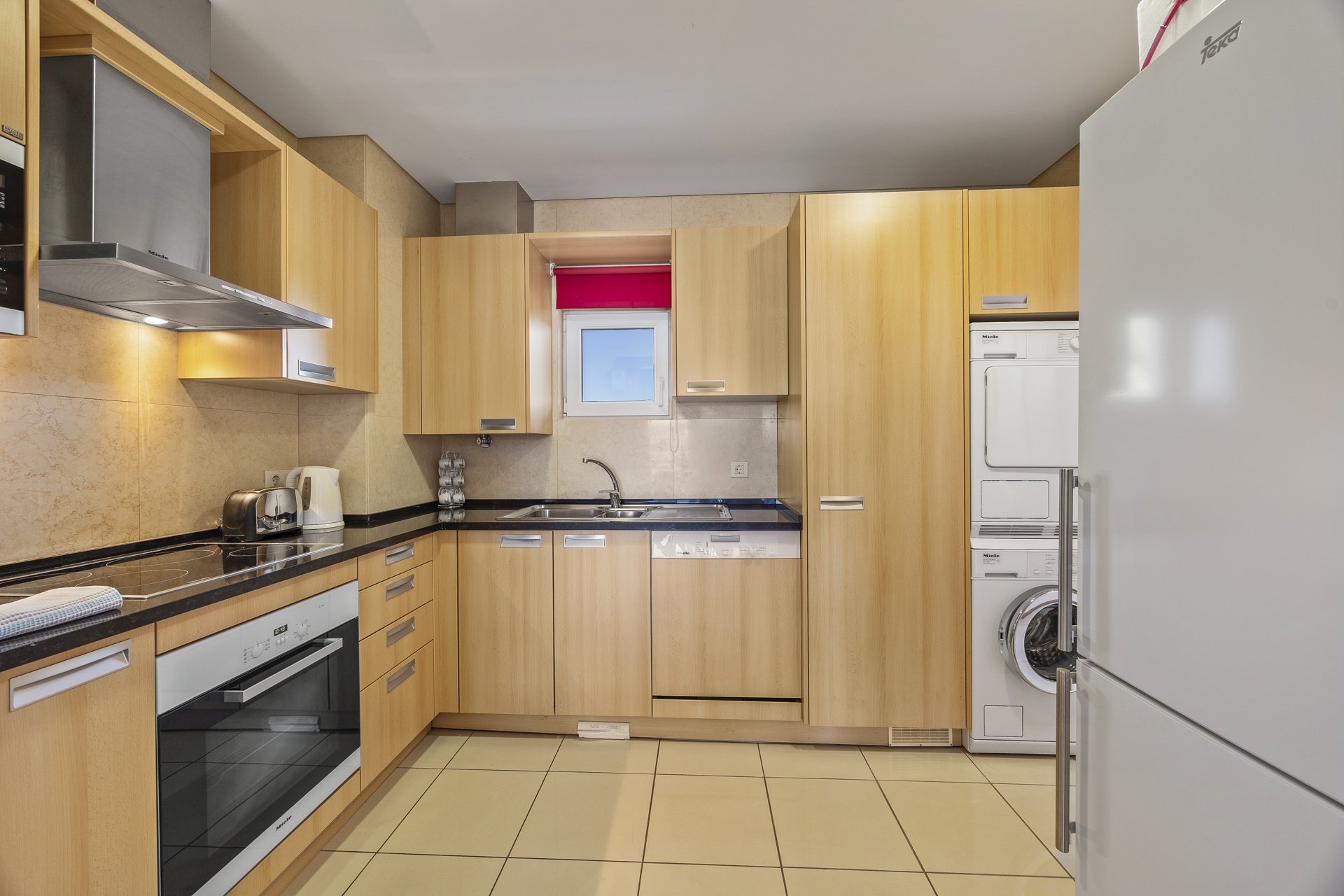 Kitchen with oven, hob, and fitted wooden cabinetry