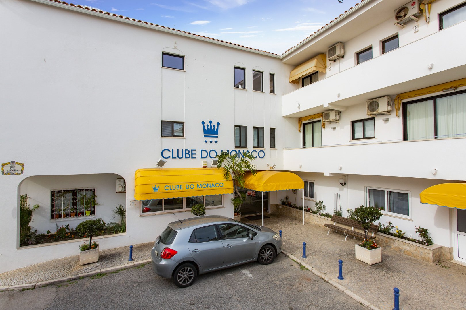 Close-up of the building entrance with Clube do Monaco signage