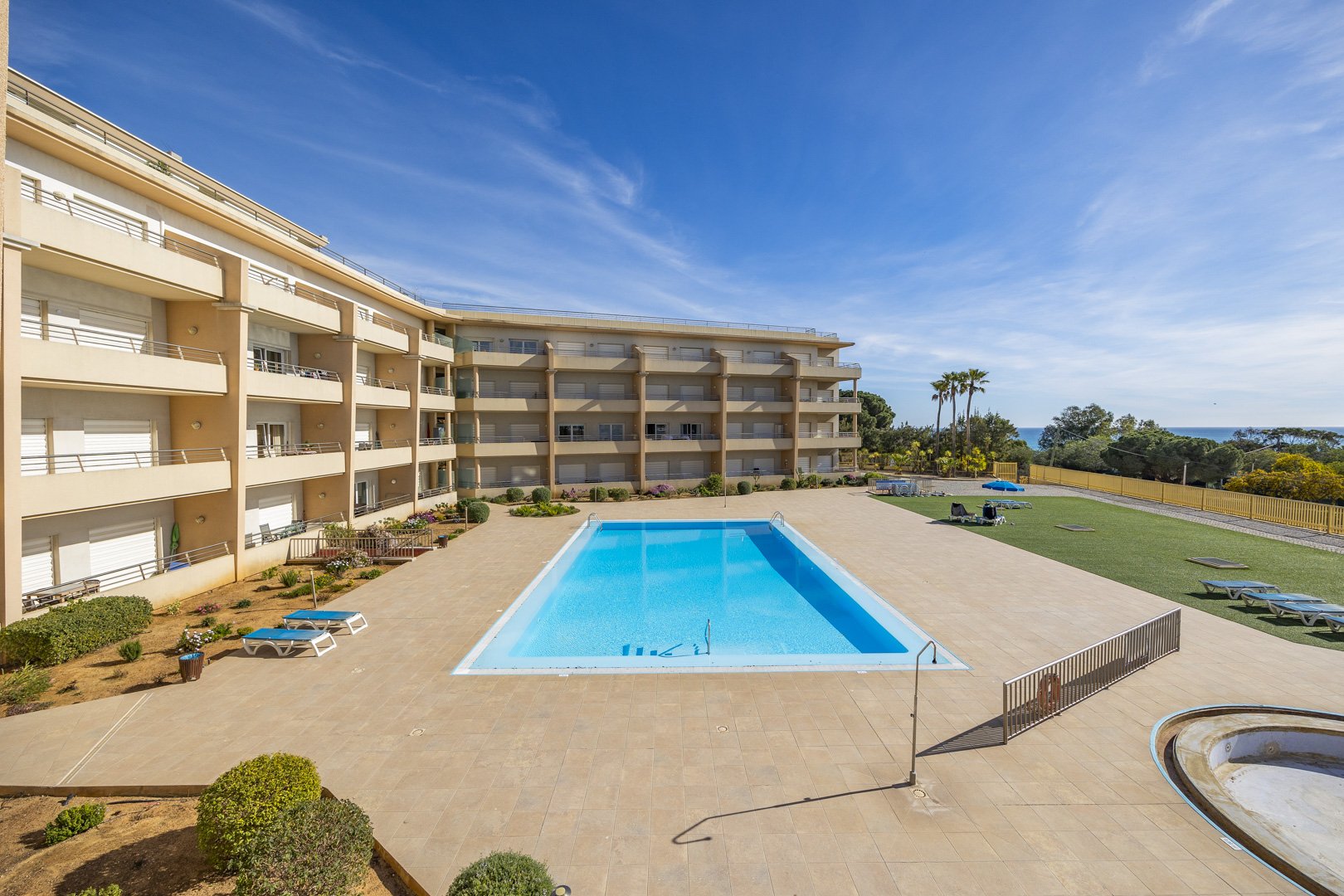 Elevated view of the building's balconies, pool, and sea beyond