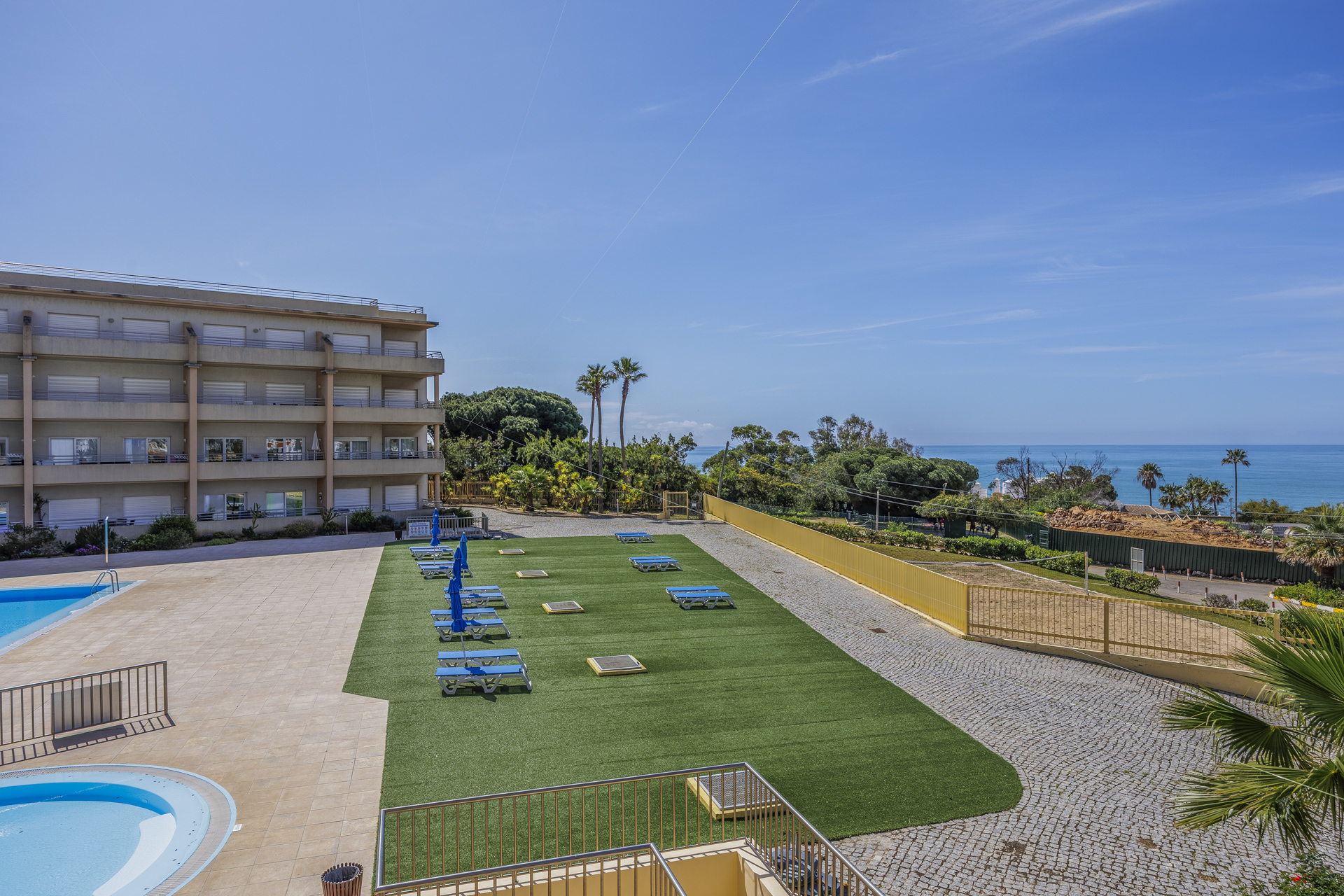 Elevated view of the pool, sun lawn, and building