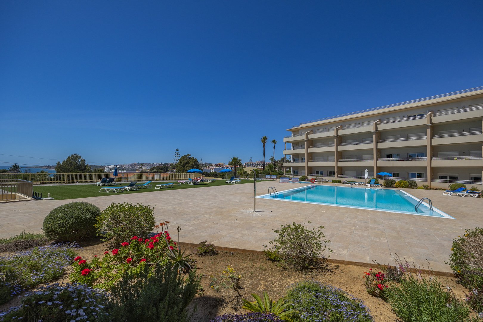 Wide view of the communal pool with the coastline in the background
