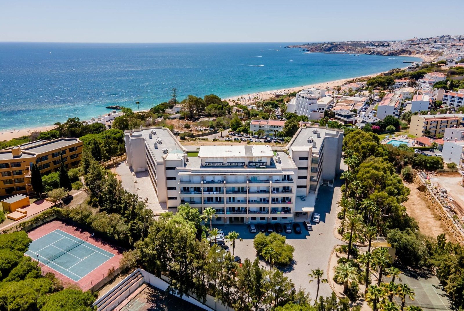 Aerial view of the complex, tennis court, and beach
