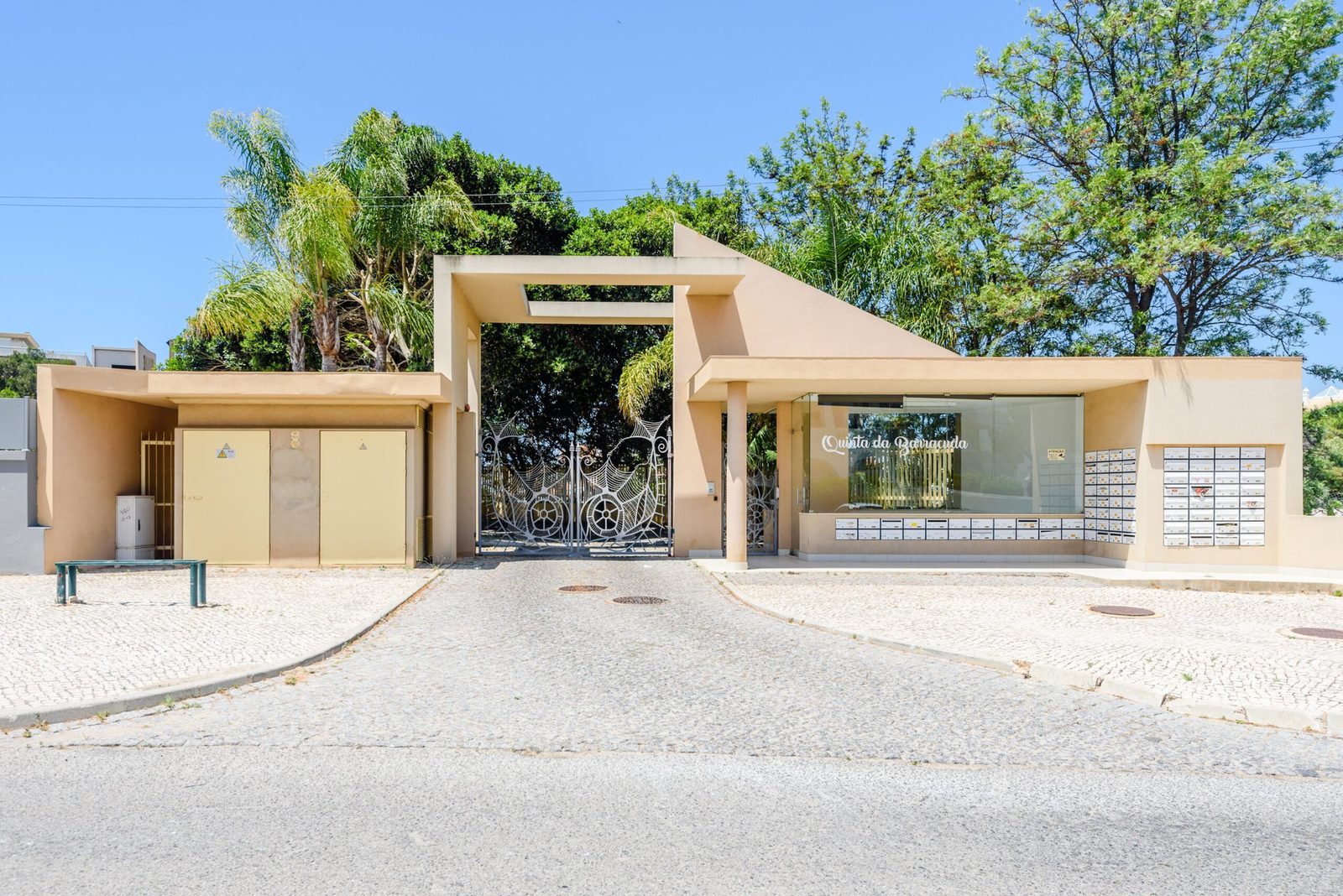 Wide view of the complex entrance gate and mailboxes