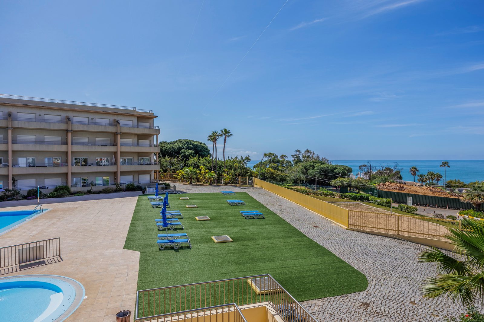 Elevated view of the pool, sun lawn, and building