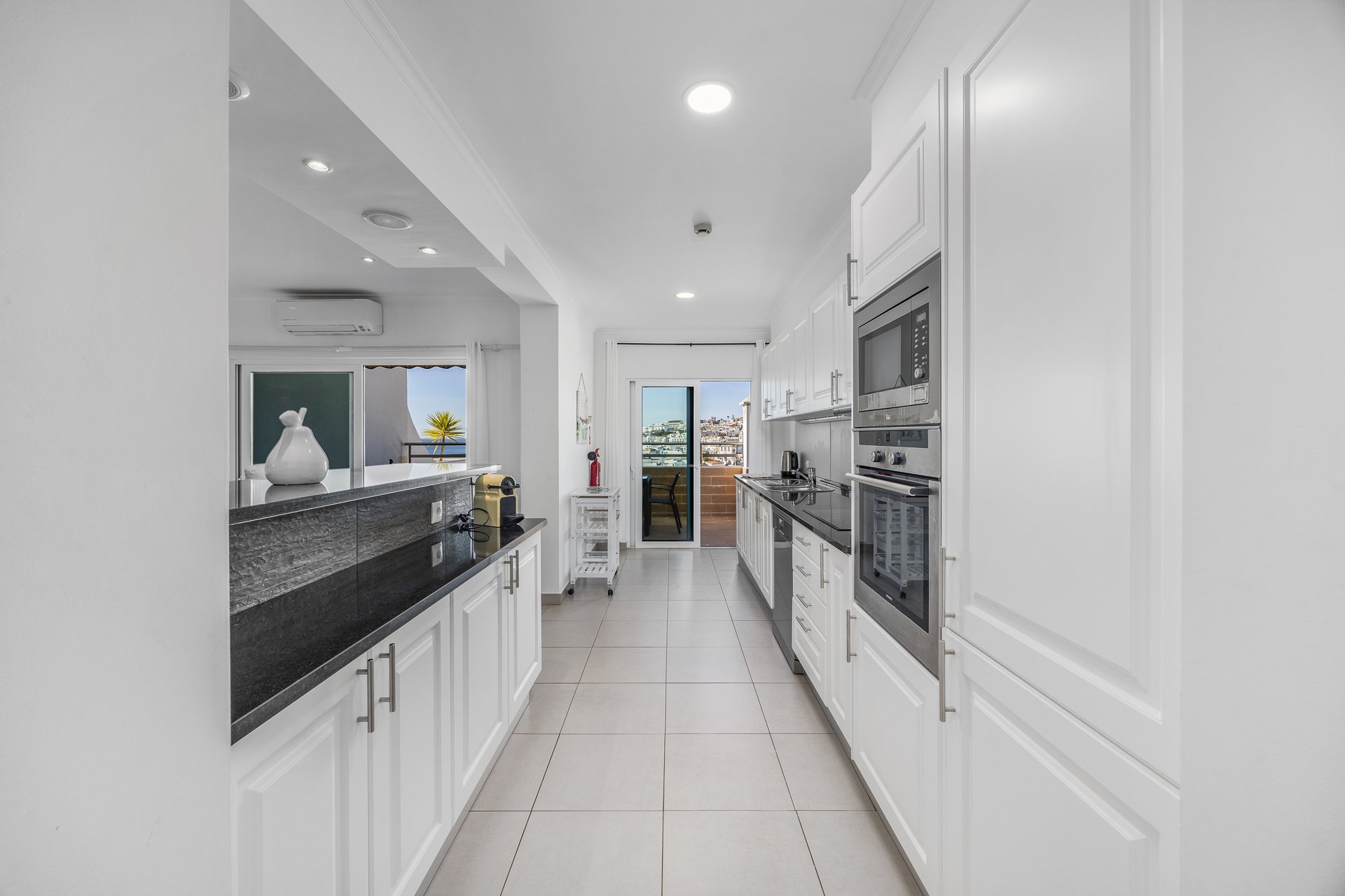 Galley kitchen with balcony access and sea view